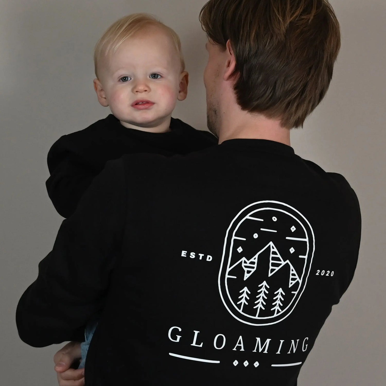 vader en baby dragen dezelfde sweater en poseren voor een foto