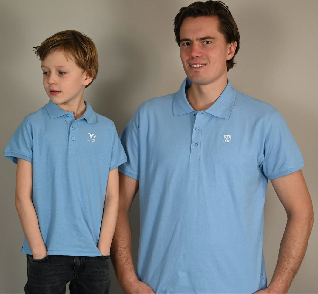 vader en zoon dragen een matchende polo terwijl ze naast elkaar poseren voor de foto